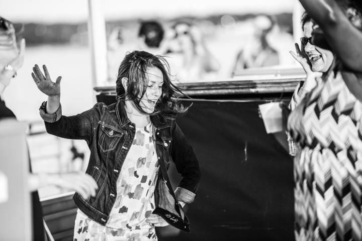 Black and white photo of a person dancing with others outdoors.