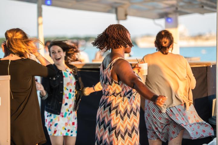 People dancing outdoors, enjoying a sunny day.