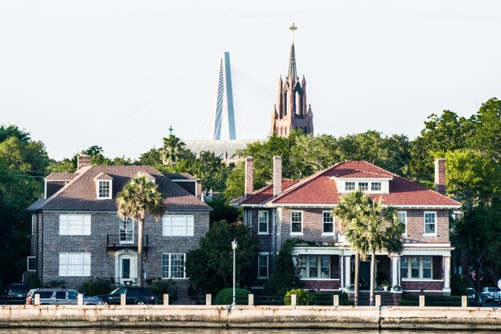 Historic buildings and church with a bridge in the background.