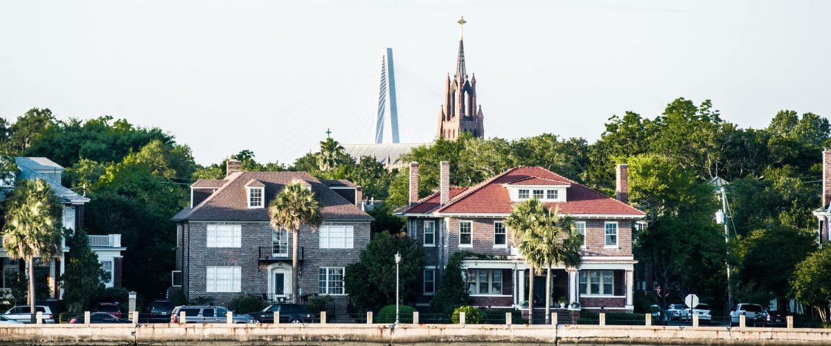 Historic buildings and church with a bridge in the background.